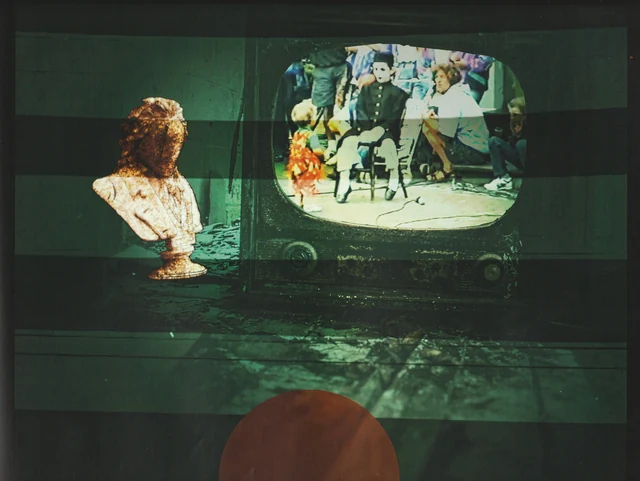 A sculpted bust facing a projected group portrait in a green room.