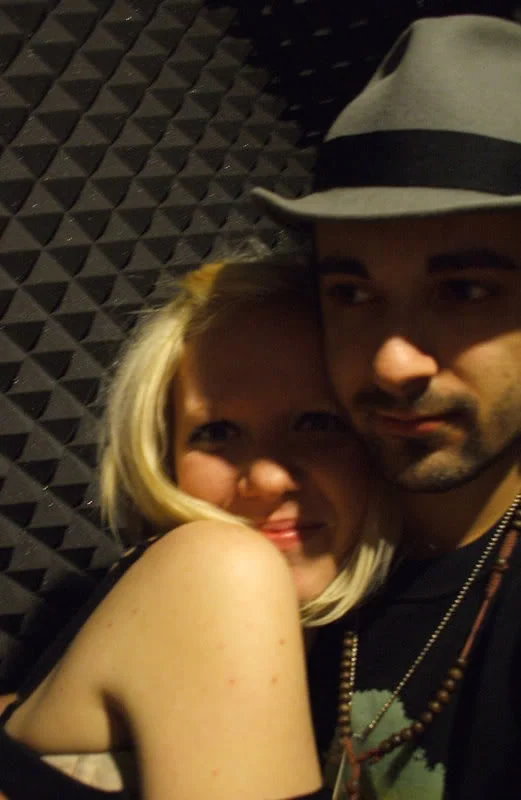 Close portrait of two people leaning together in a music room.